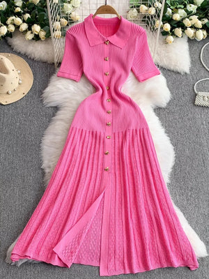 Pink ribbed knit midi dress with collar, short sleeves, and gold button detail.
