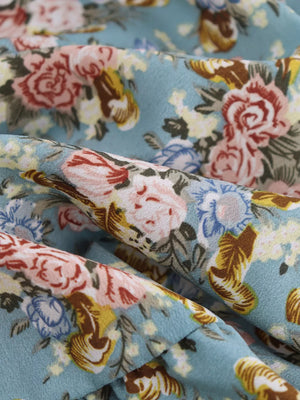 Vibrant floral print mini dress with a halter neck and deep V-neck.
