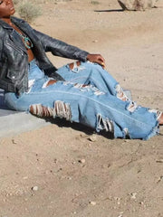 Distressed wide-leg maternity jeans in light wash denim with heavy rips and frayed hems.
