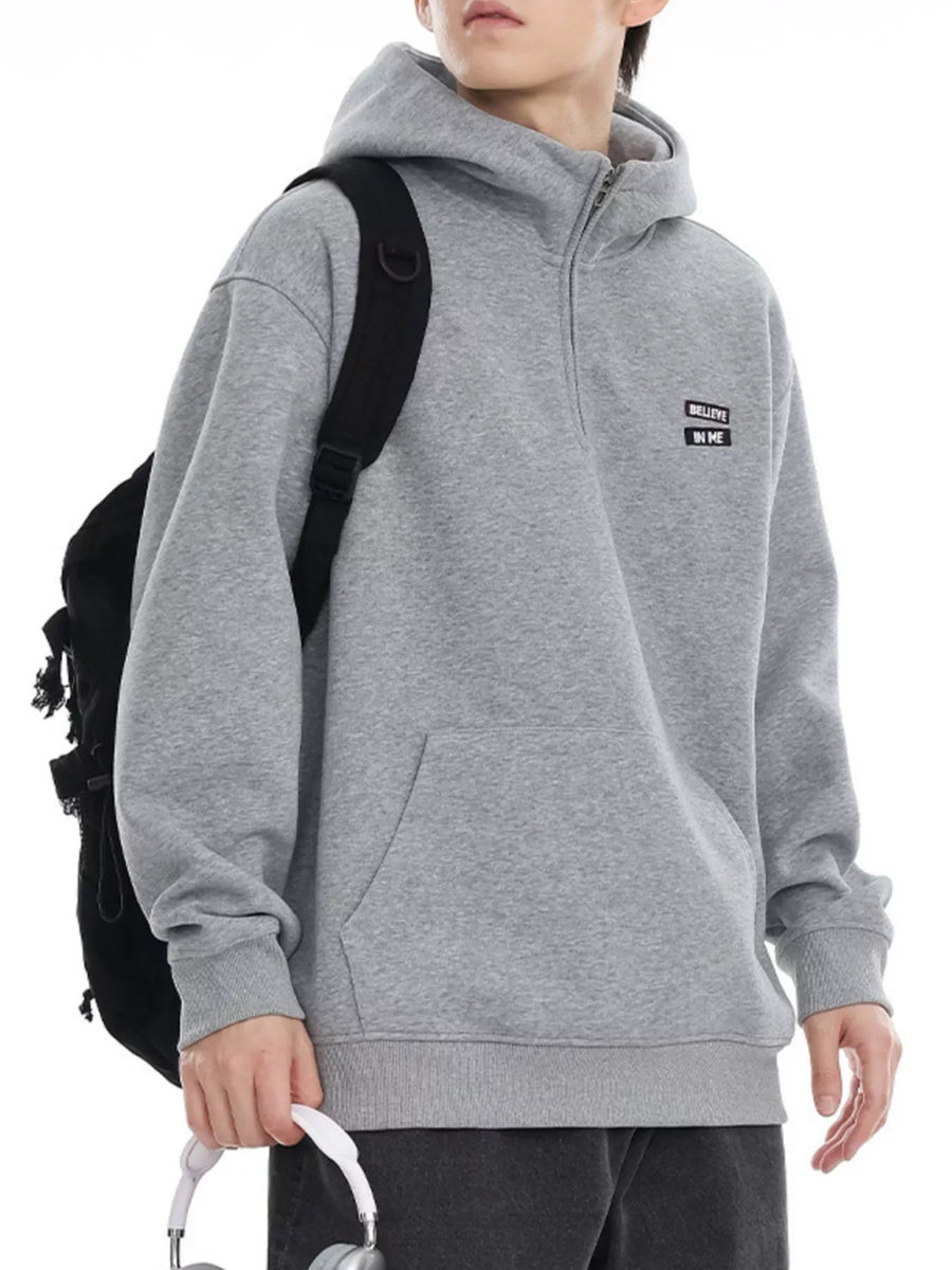 Plus-size grey quarter-zip hoodie with a kangaroo pocket and a small embroidered patch.