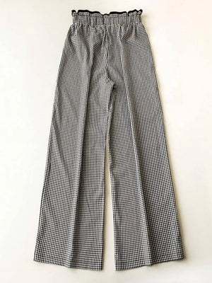 High-waisted wide-leg gingham pants with a ruffled black waistband.