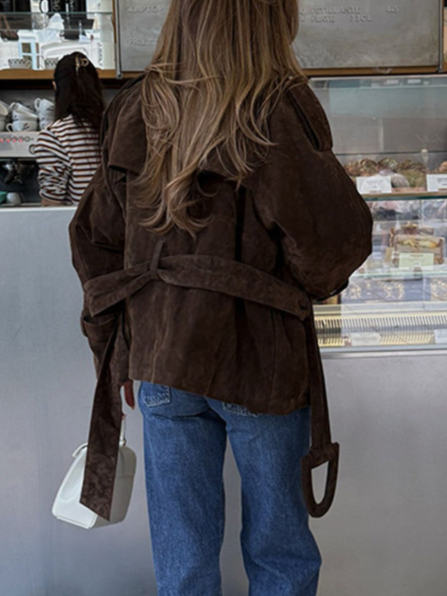 Brown belted trench coat with lapel collar and tie waist detail.