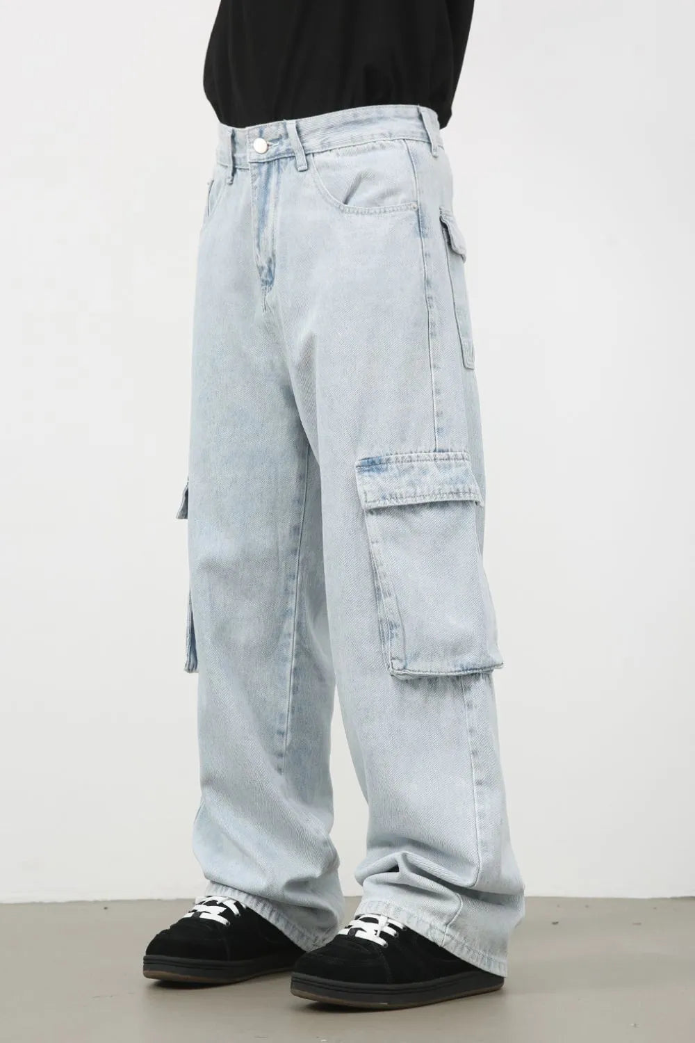 Oversized light wash denim cargo pants with multiple pockets.