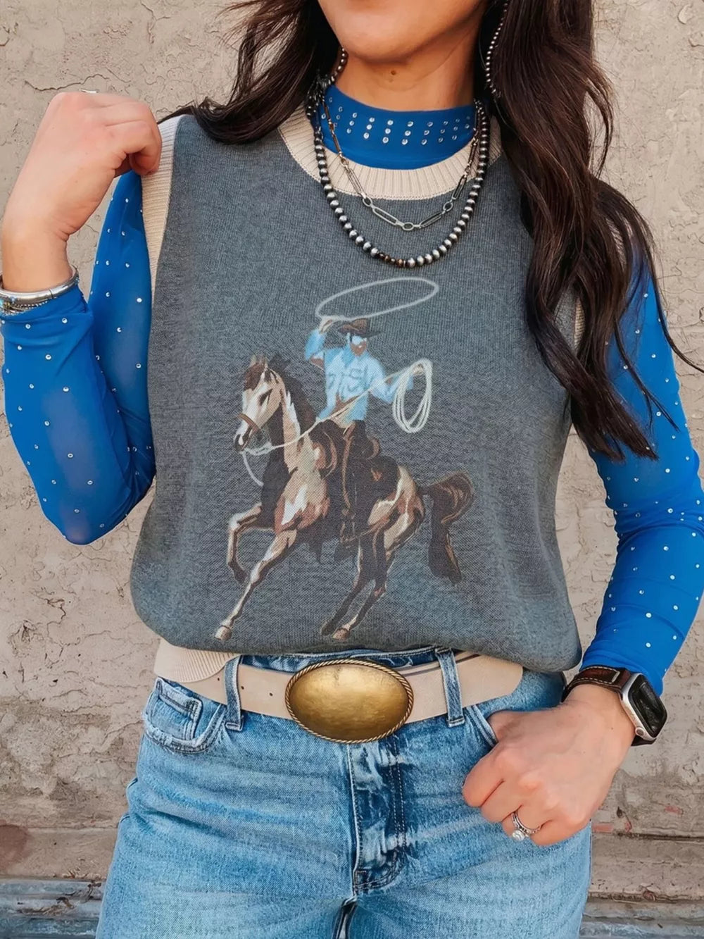 Cowboy graphic cotton knit vest with cream trim and crew neck, styled over a blue mesh top.