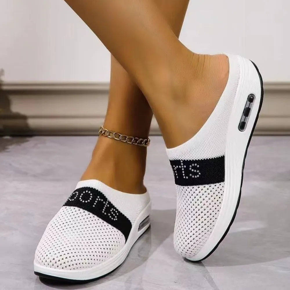 White mesh slip-on athletic shoes with black "SPORTS" band and air cushion detail.