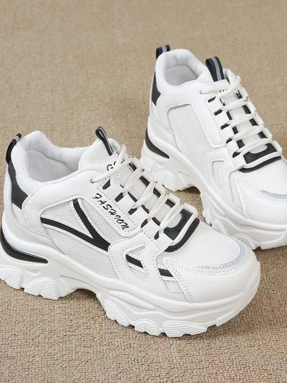 White chunky sneakers with mesh and leather details and black accents.