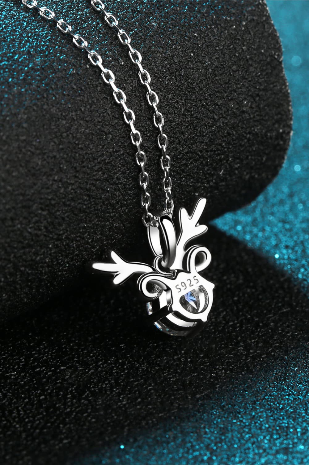 Silver reindeer pendant necklace with moissanite on a sterling silver chain.