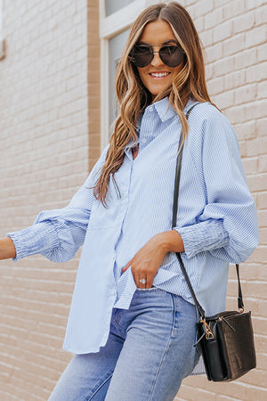 Pastel blue pinstripe blouse with balloon sleeves and ruched cuffs, styled with jeans.