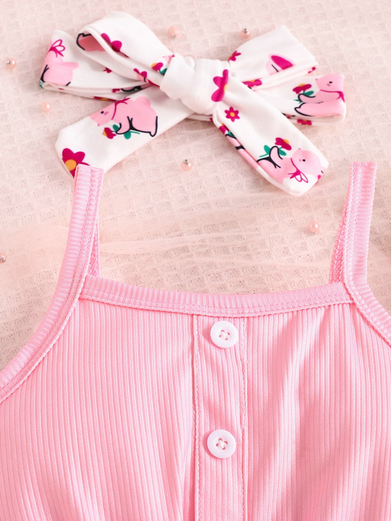 Pink ribbed tank top with button detail and matching printed headband.