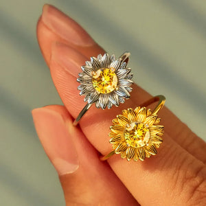 Sunflower petal rings in gold and silver with yellow gemstone centers.