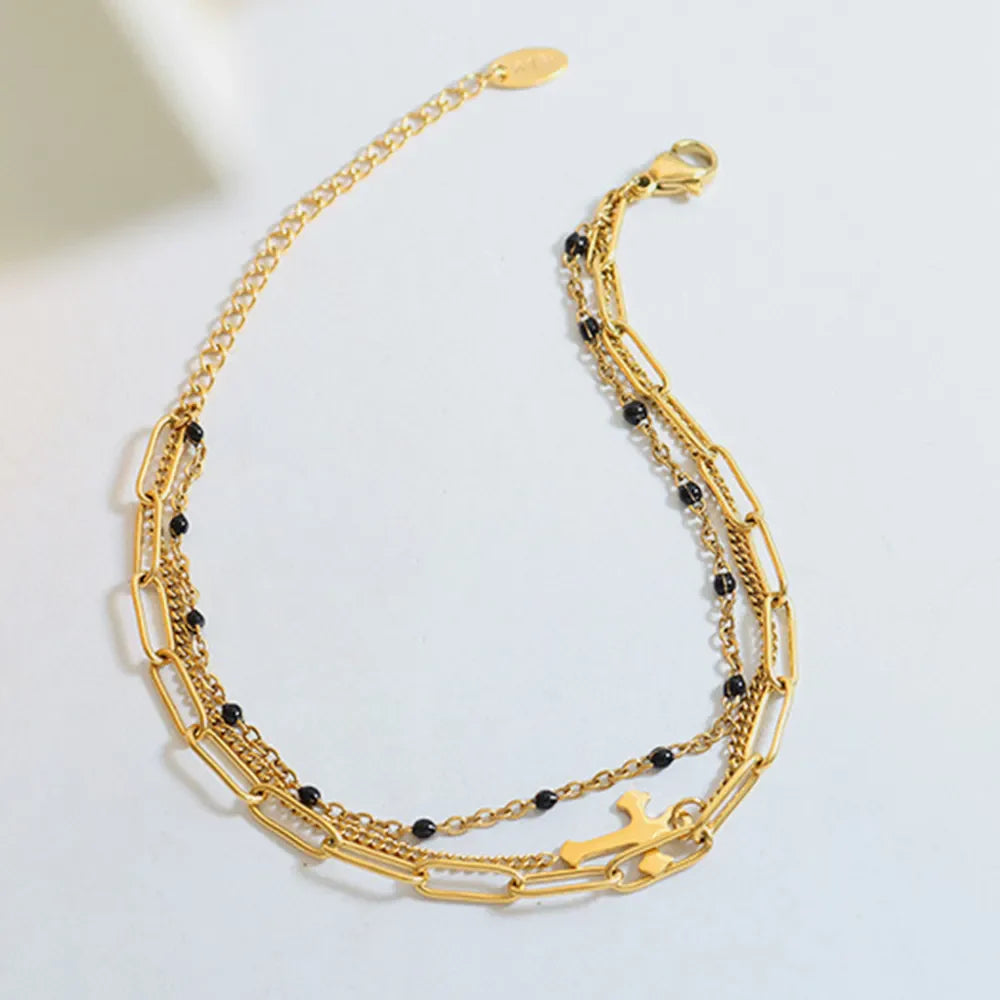 Gold layered chain and bead bracelet trio with cross charm