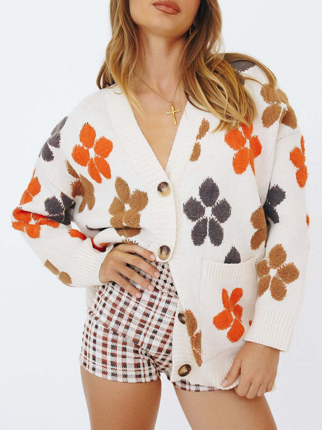 White knit cardigan with floral appliqué, V-neck, button-front, and pockets.