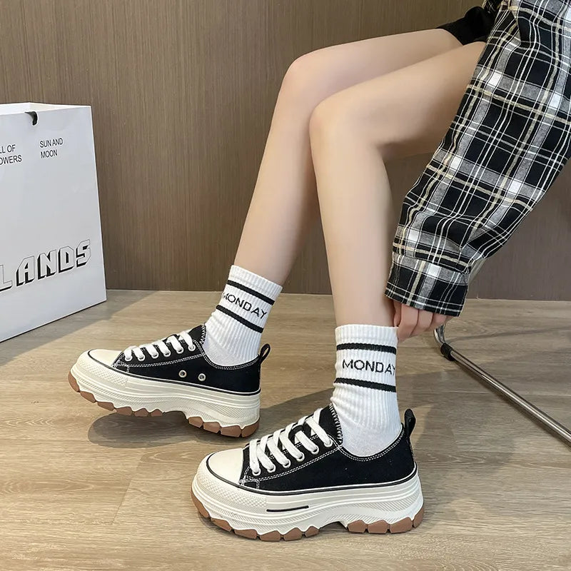 Black canvas tread sneakers with white laces and thick white soles.