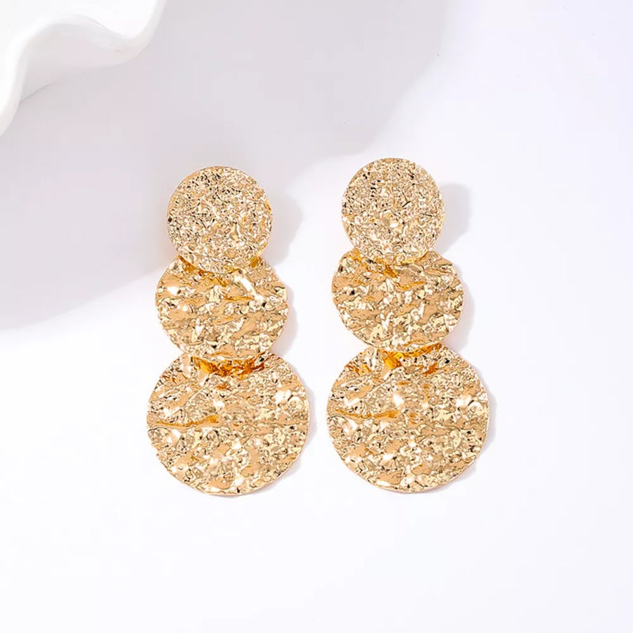 Golden earrings featuring layered and textured