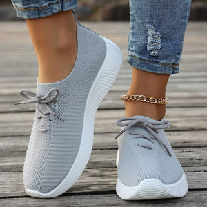 Gray breathable lace-up sneakers with white mid sole and laces.