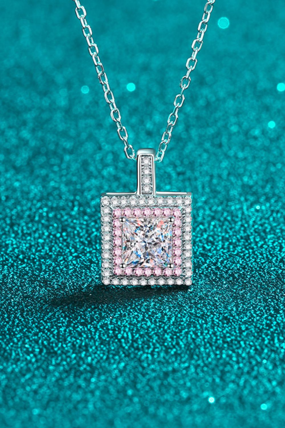 Silver moissanite halo pendant necklace with square-cut center stone and pink accent stones.