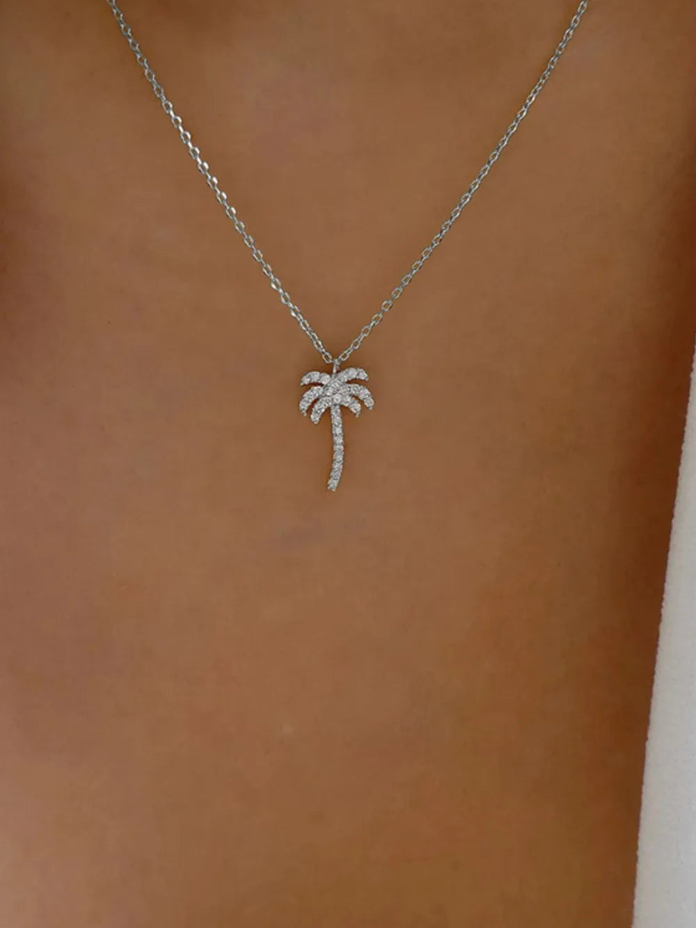 clear necklace featuring adjustable chain and palm tree motif