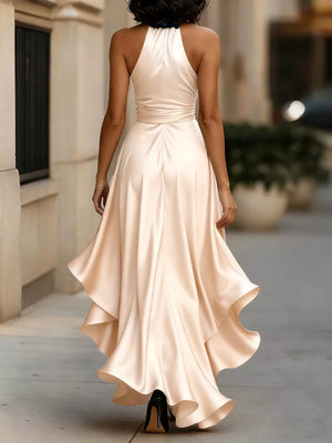 Elegant tan halter maxi dress with ruffled asymmetrical hem and belted waist.