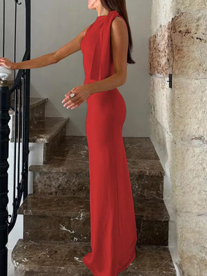 Red asymmetrical draped maxi dress with a halter neckline and flowing sash detail.