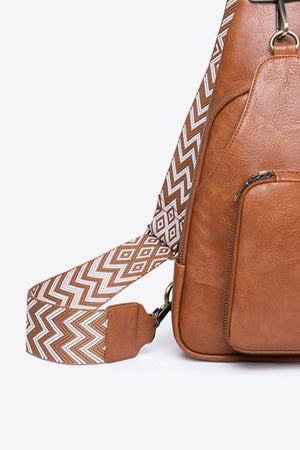 Honey PU sling bag with geometric patterned strap and zipper pocket detail.