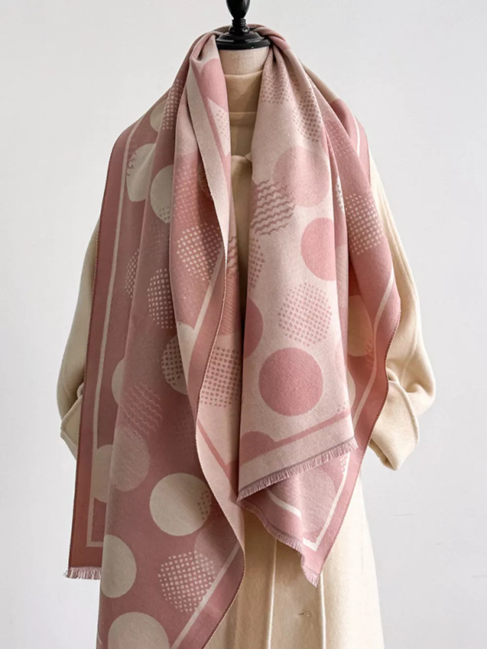 Dusty pink polka dot textured scarf with fringe and geometric patterns.