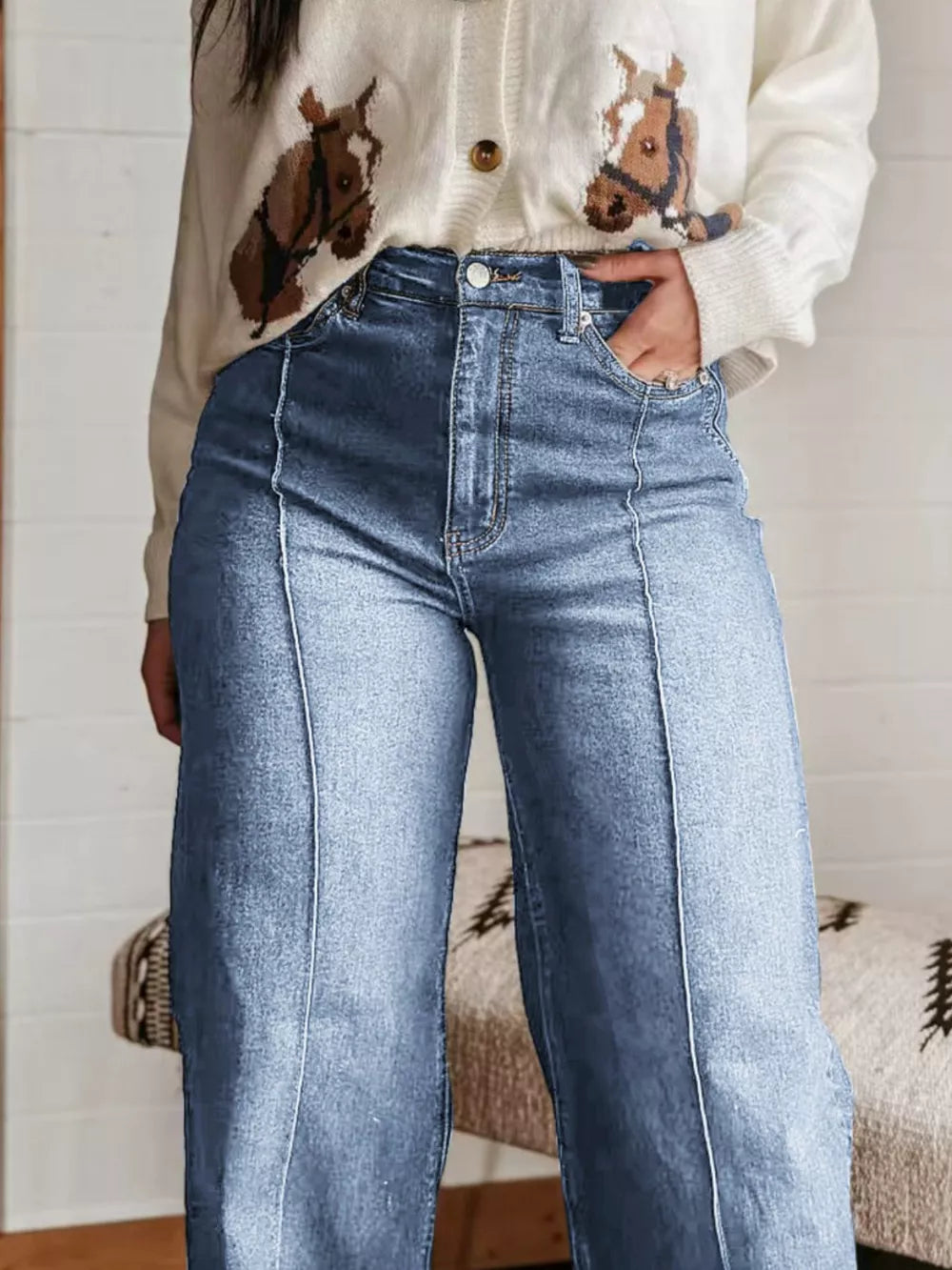 Light blue denim wide-leg jeans with buttoned pockets and front seam detail.