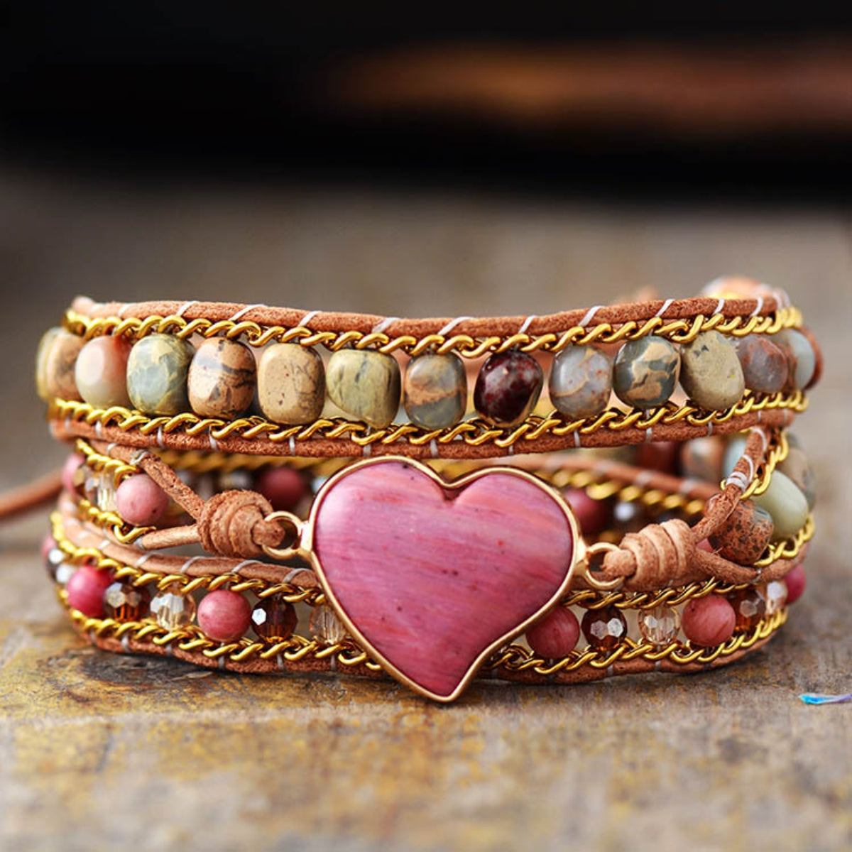 Bohemian wrap bracelet with multicolor stones, gold chain, and pink heart charm.