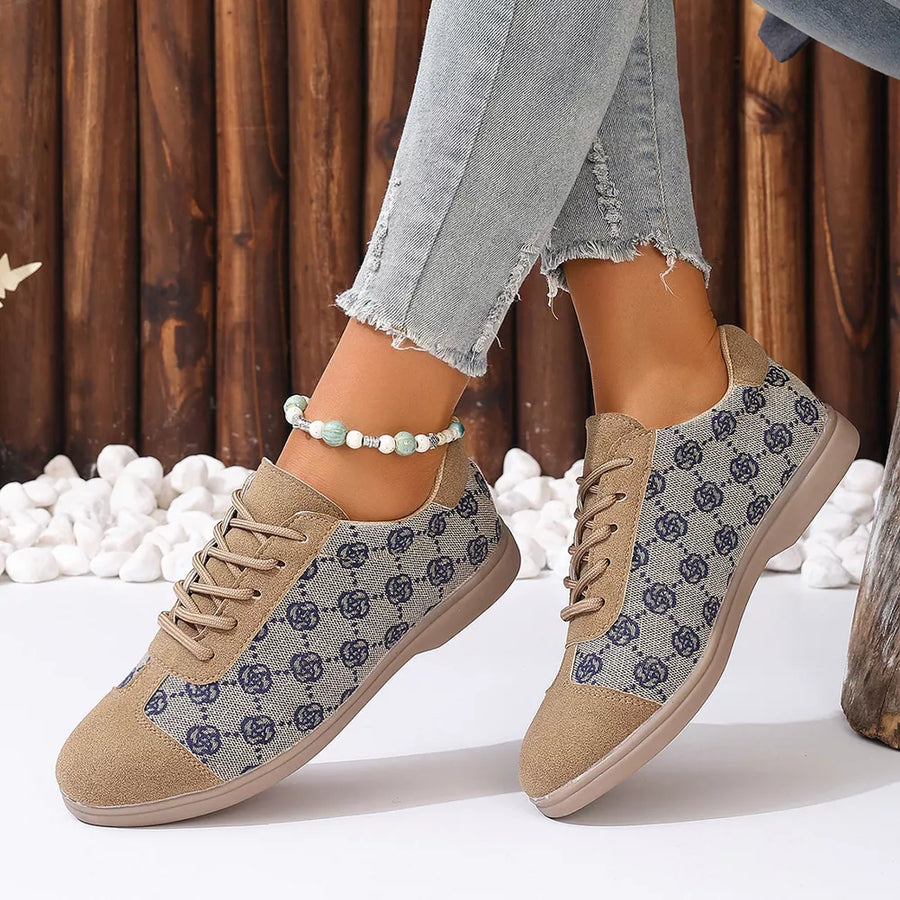 Chic lace-up sneakers in tan with a blue monogram pattern and lace-up closure.