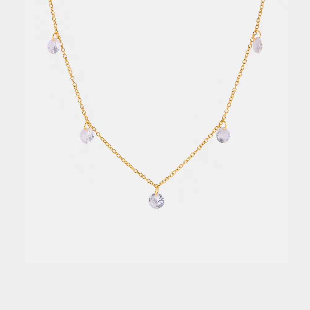 Gold dangling crystal station necklace with five clear cubic zirconia charms.