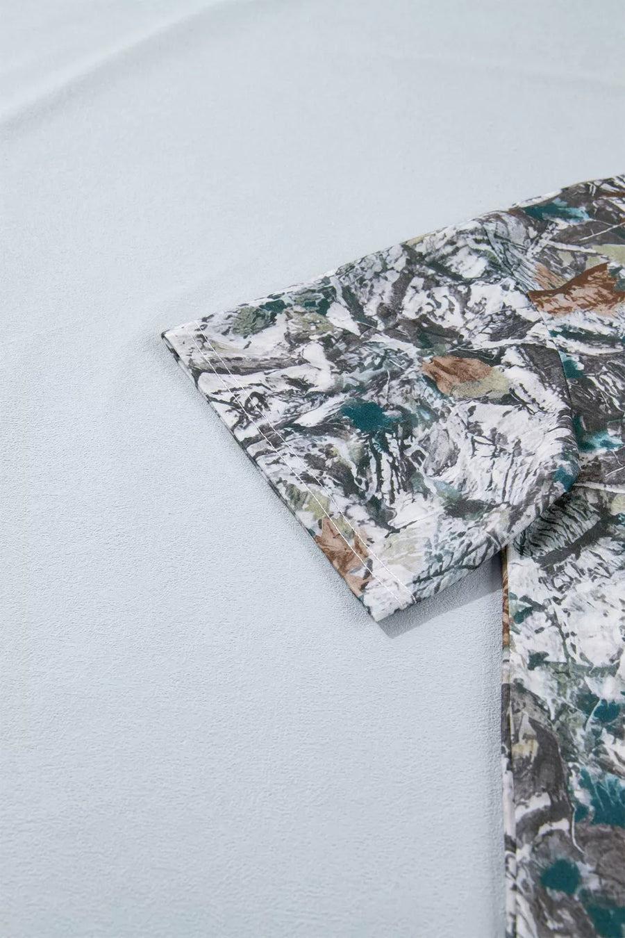 Earthy camouflage print henley t-shirt with short sleeves and button detail.