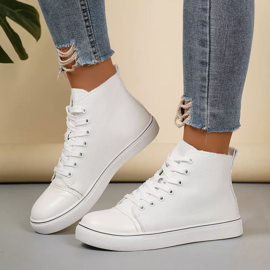 White canvas high-top sneakers with lace-up closure and contrast toe cap.
