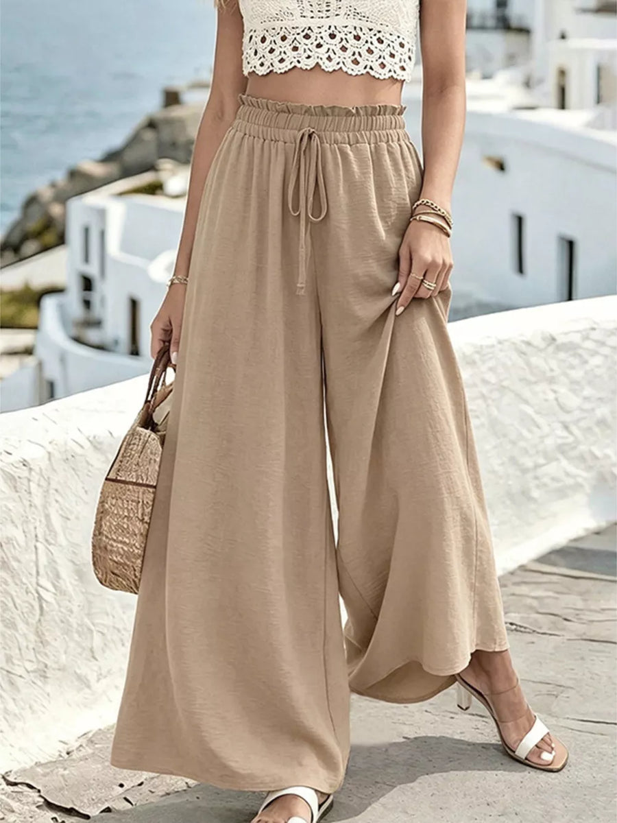 Beige linen blend wide-leg pants with drawstring waist and ruffled detail.