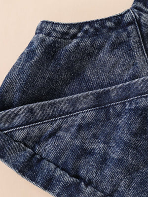 Acid-wash denim cami detail with visible stitching and texture.