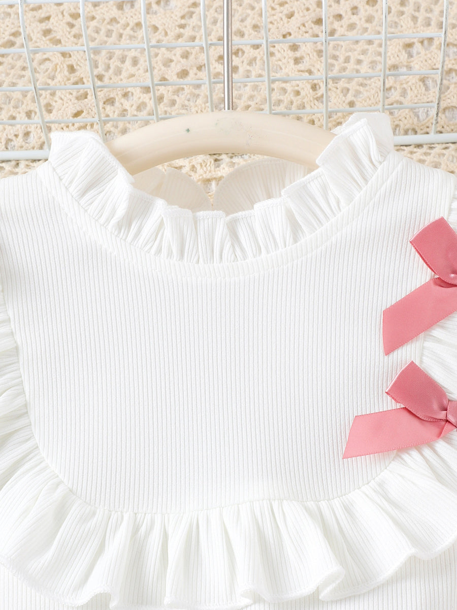 White ribbed toddler top with ruffled neckline and pink bows