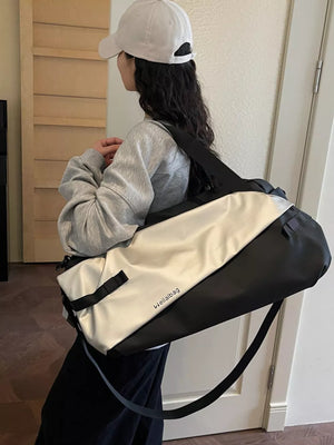 Oxford cloth travel bag in silver and black with a diagonal color block design and shoulder strap.