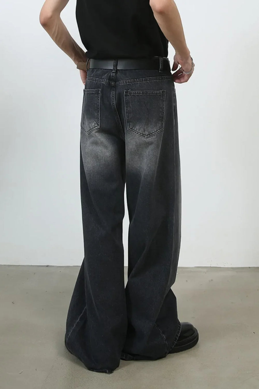 Black faded wash palazzo jeans with a wide leg and pleated detail.