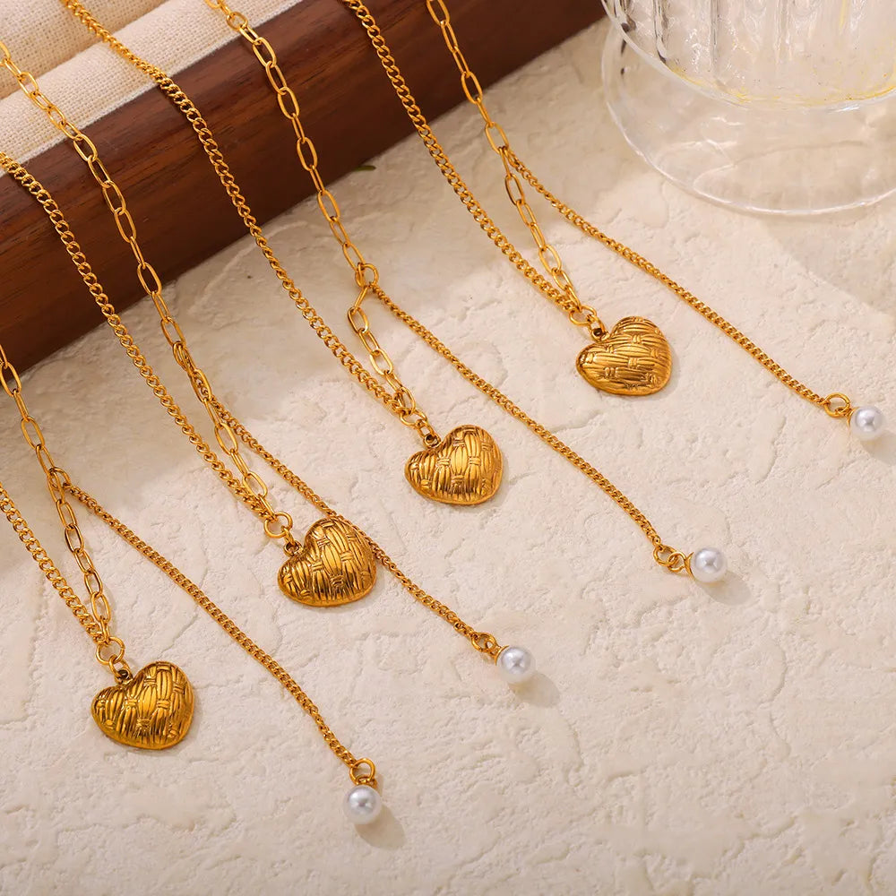Gold textured heart and pearl drop necklaces with delicate chains.