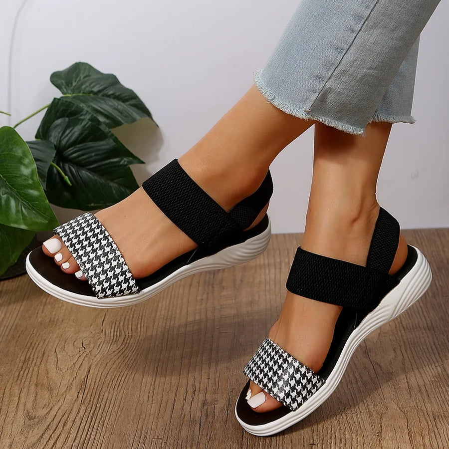 Geometric print elastic strap sandals in black and white houndstooth with black straps.