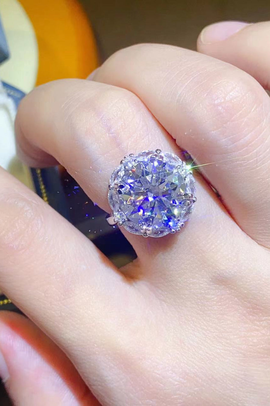 Silver moissanite halo statement ring with large round center stone.