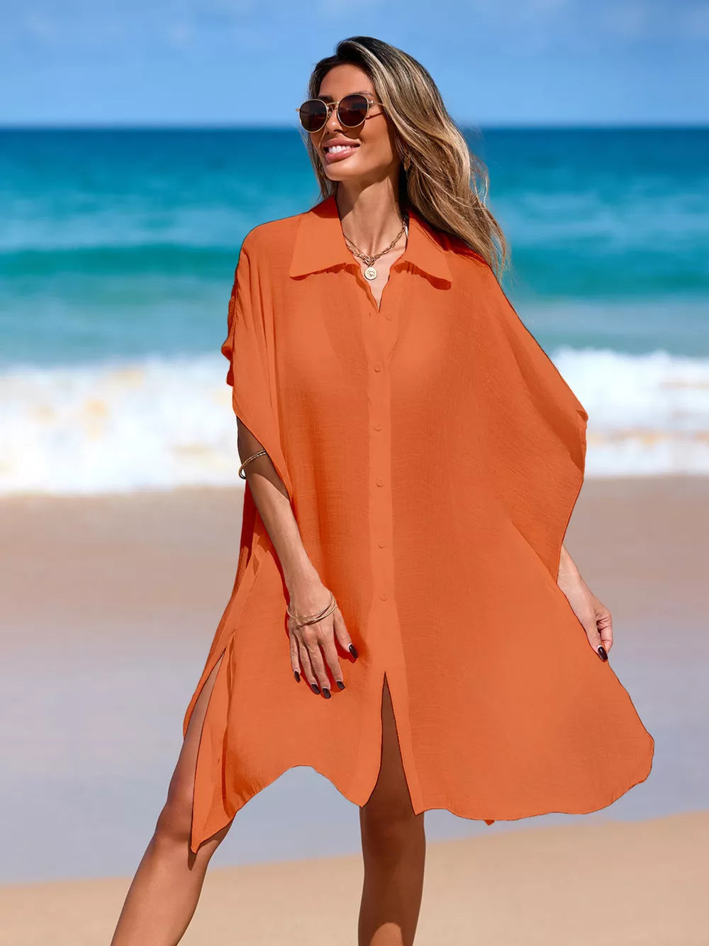 Orange button-up cover-up with short sleeves and high slits, worn by a woman on the beach.