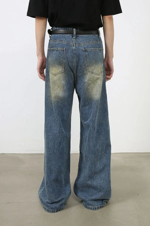 Faded patchwork denim palazzo trousers in medium wash, featuring a wide leg and distressed details.