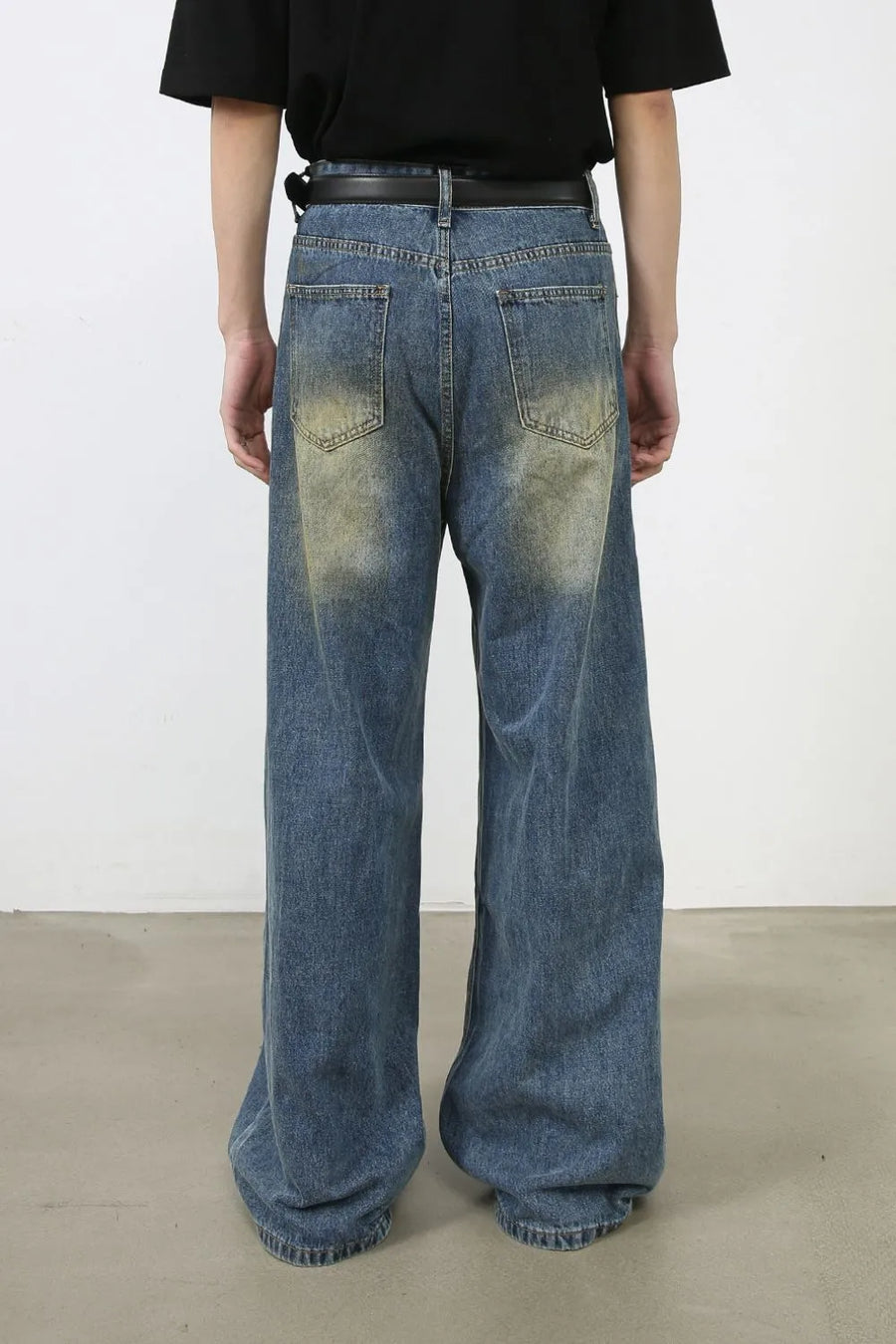 Faded patchwork denim palazzo trousers in medium wash, featuring a wide leg and distressed details.