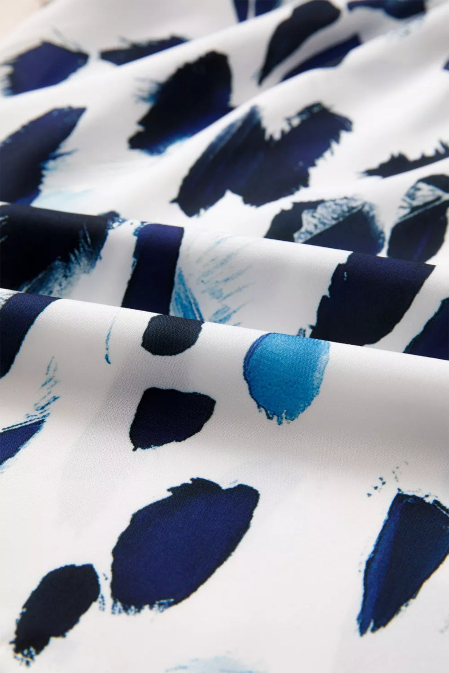 Vibrant abstract print polyester shirt with ruffled V-neck detail.