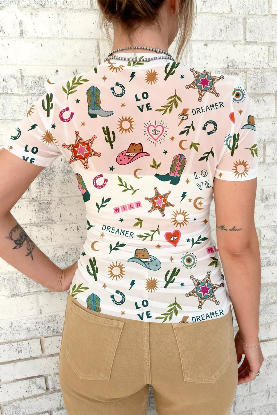 Women's white mesh tunic with colorful western print, short sleeves, and crew neck.