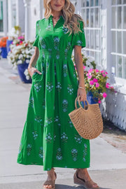 Green floral maxi dress with smocked waist, short sleeves, and tiered skirt.