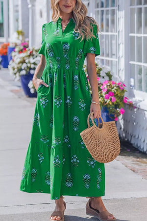 Green floral maxi dress with smocked waist, short sleeves, and tiered skirt.