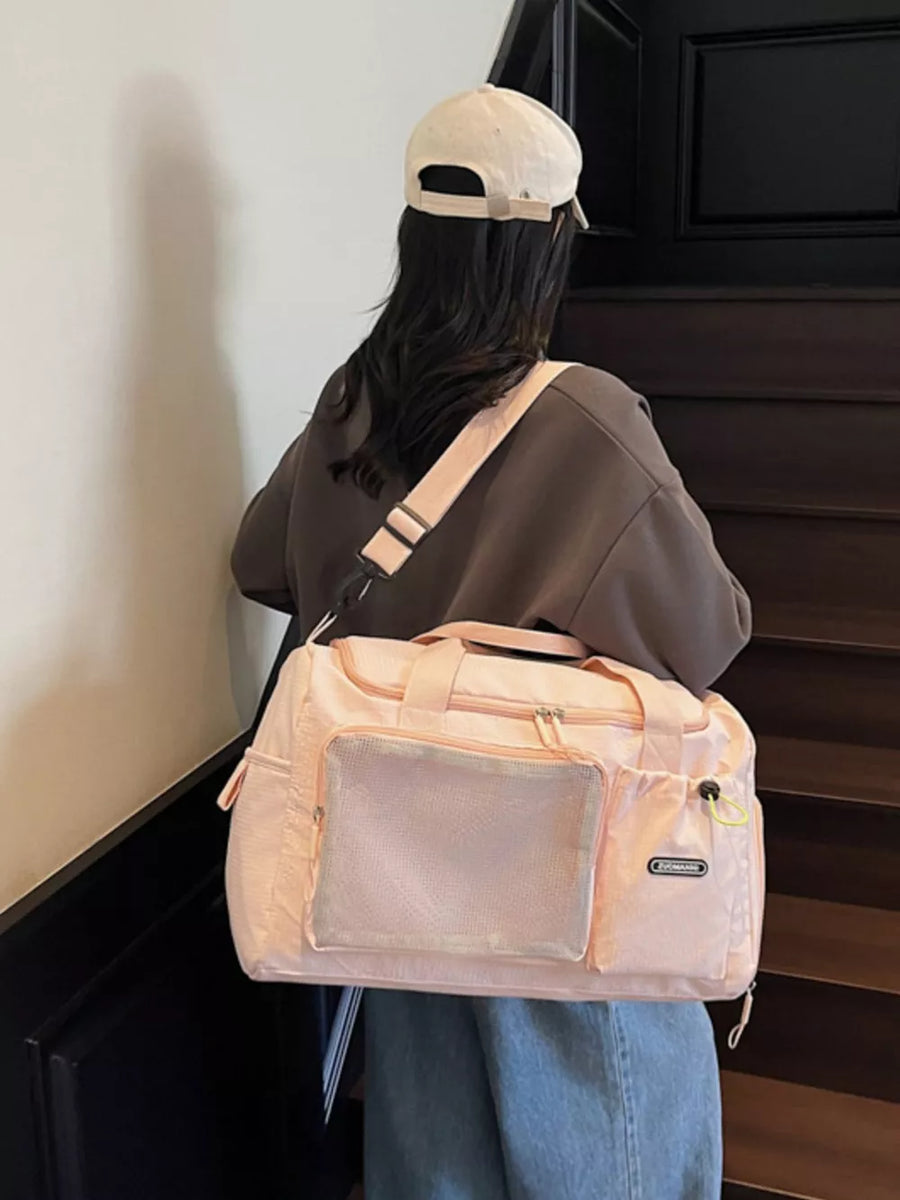 Pink duffel bag with mesh front pocket and adjustable strap