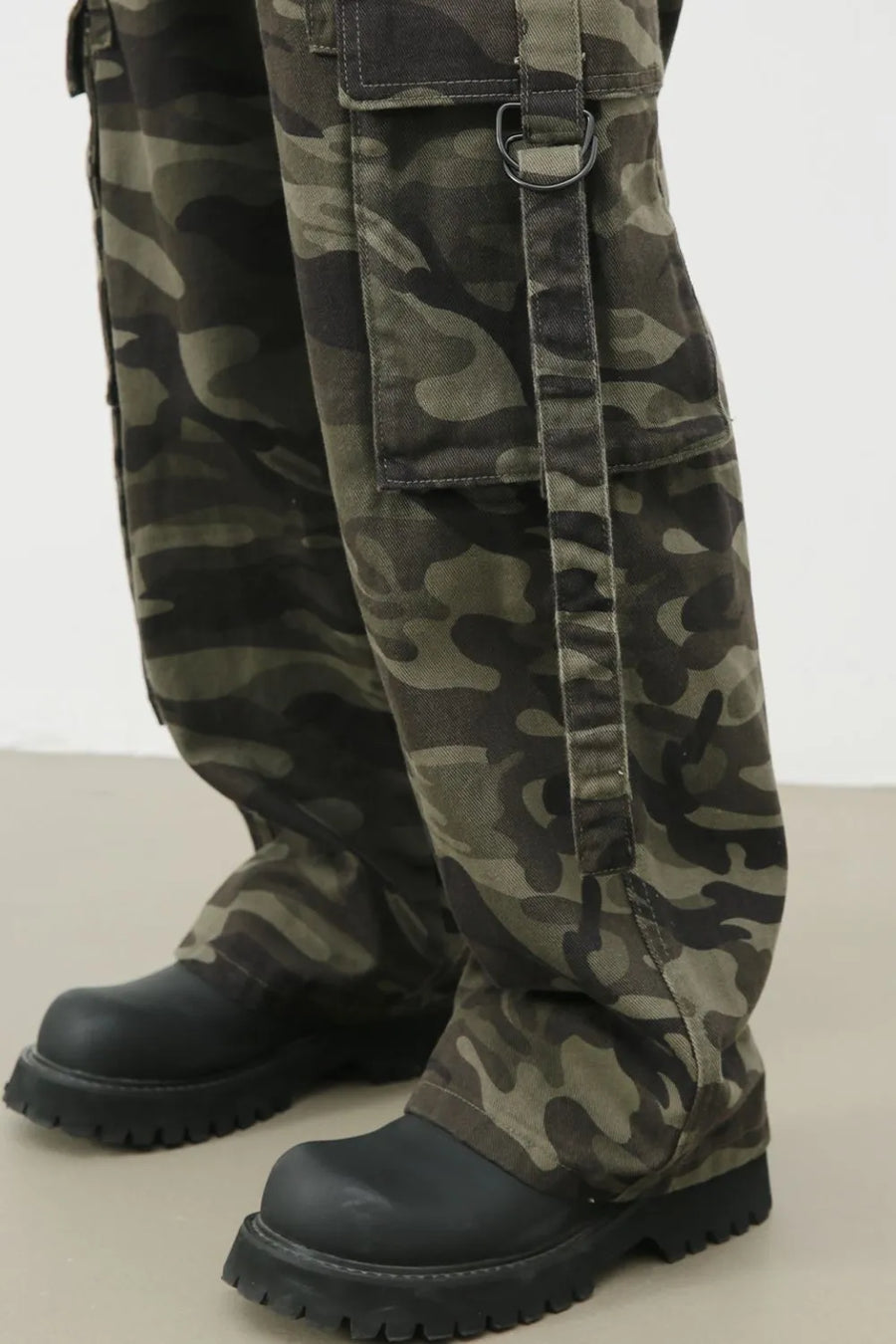 Wide-leg camo cargo pants with belt detail and D-ring accent.