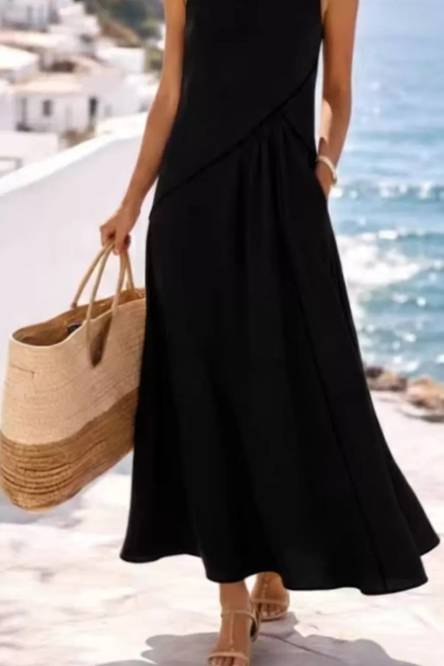 Black maxi dress with contrast detailing and pockets, sleeveless, flowing skirt.