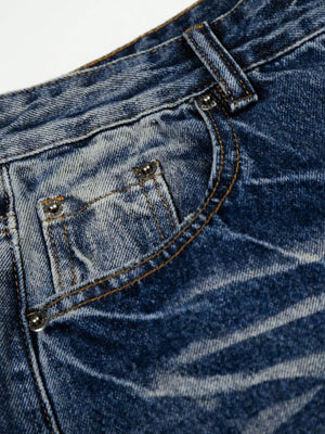 Men's light blue vintage wash wide leg jeans with distressed details.